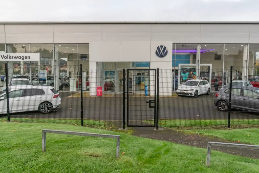 Black security gate with lock installed for VW car dealership by Direct Fencing & Contracting