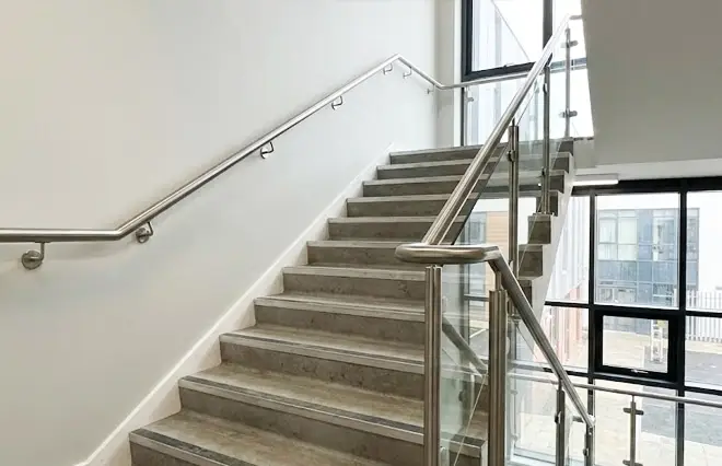 Handrails & Railings featuring wall-mounted and glass post stainless steel handrails along a commercial staircase.
