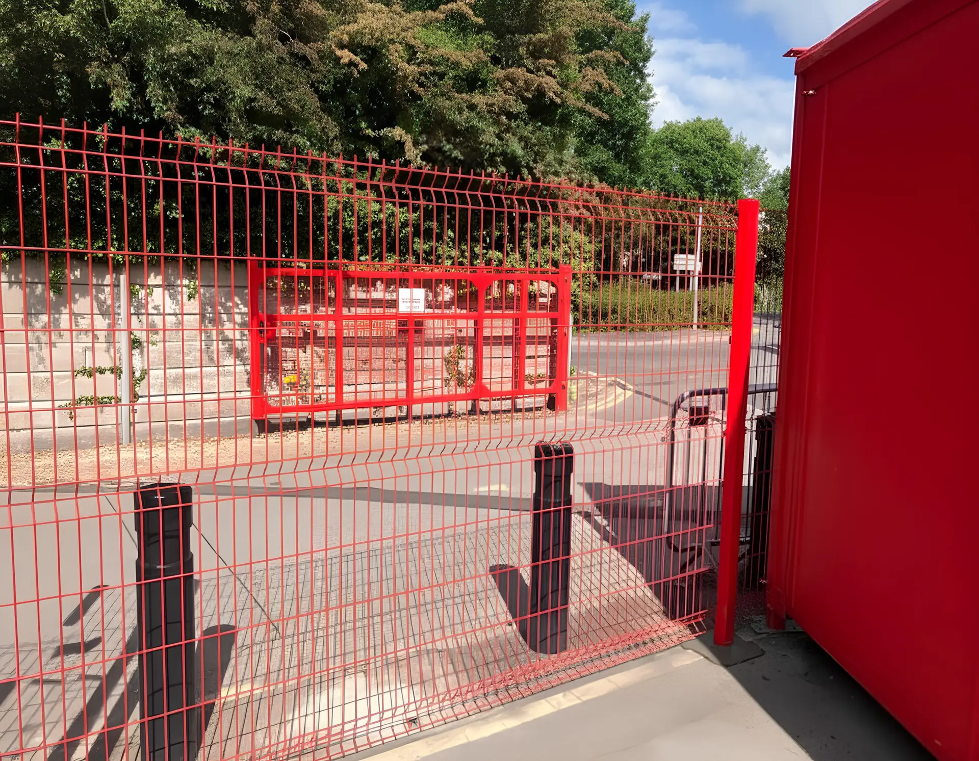 Sports Ground Fencing featuring red profile mesh panels and a matching red entrance gate.